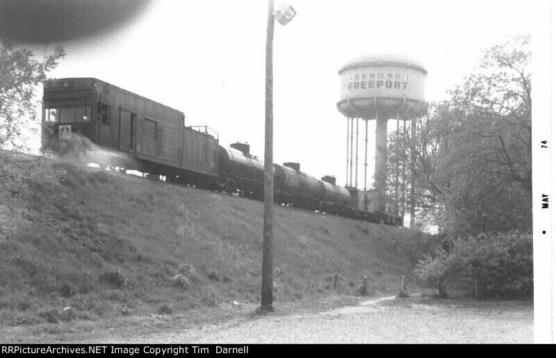 Weed sprayer passes Freeport water tower.